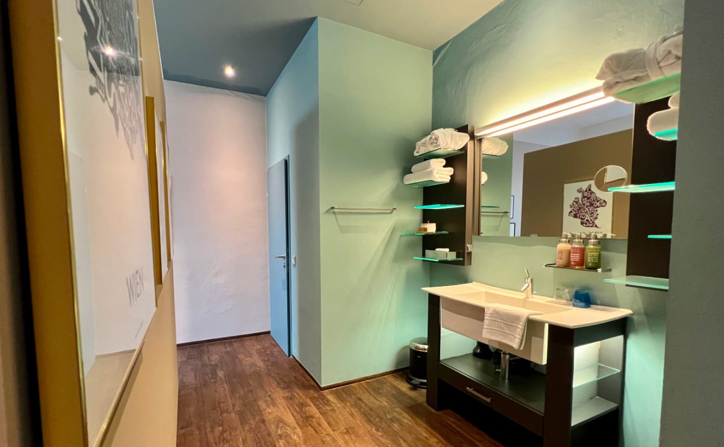 Offener Badezimmerbereich mit Waschtisch und stilvoller Beleuchtung in der Junior Suite